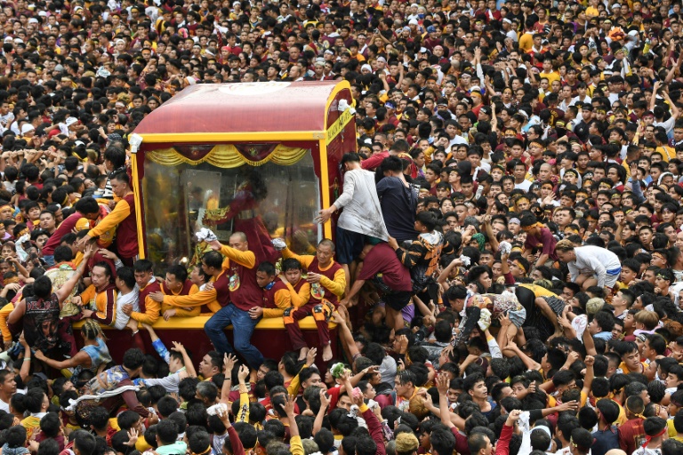 Católicos filipinos nadan el icono de Cristo en una calurosa procesión